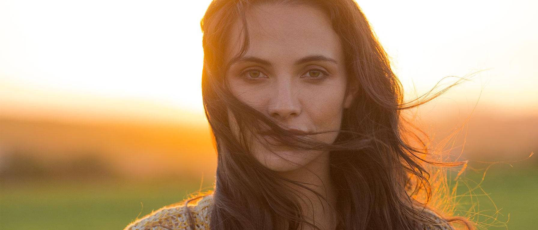 Beautiful woman on field during sunset