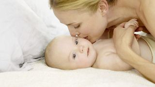 Baby with sensitive skin get kiss from mommy