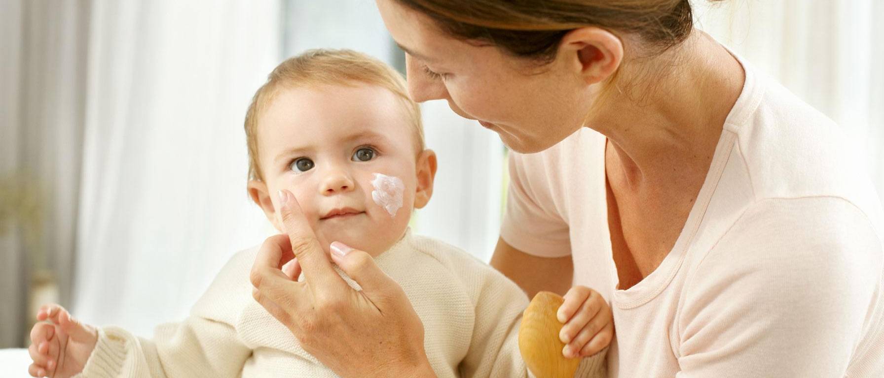 Mommy applies face cream on baby