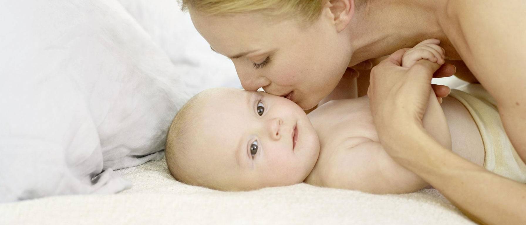 Baby with sensitive skin get kiss from mommy