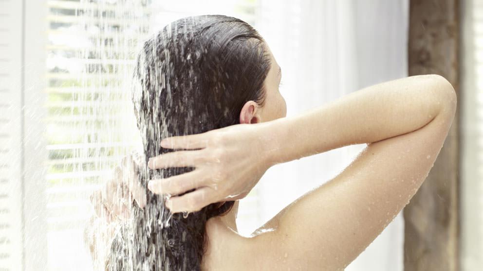 Woman washes out shampoo - Weleda